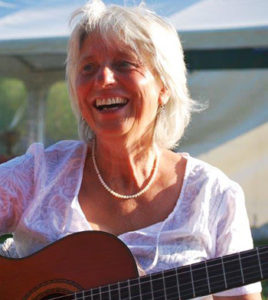 Bild von Alwine Deege mit Gitarre bei Auftritt im Freien