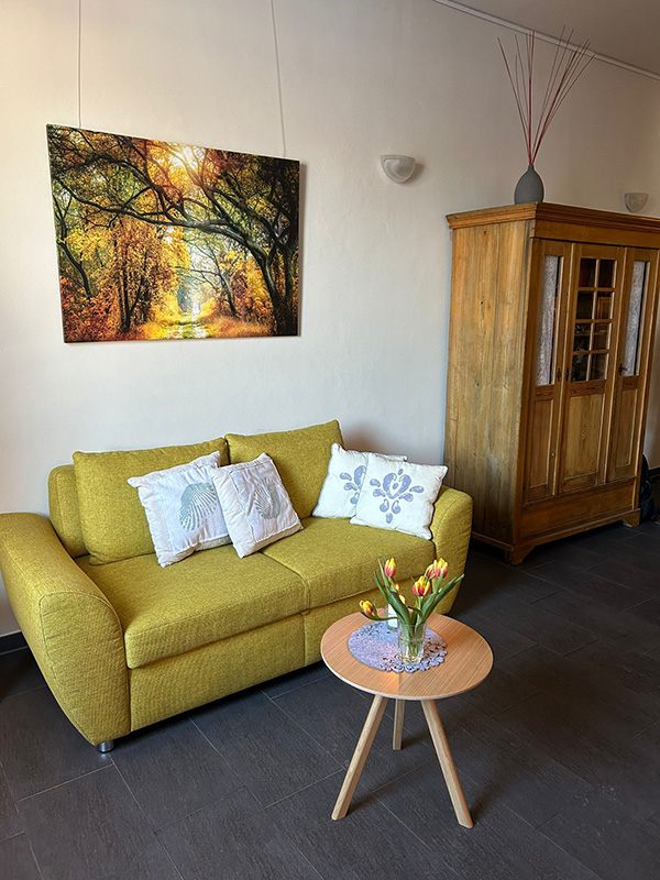 Grünes Sofa und Schrank, beruhigende Atmosphäre in den neu gestalteten Räumlichkeiten des Hospiz in Frechen